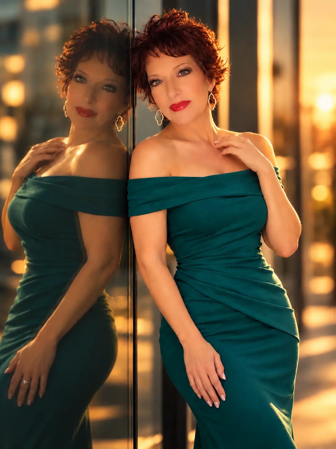 Editorial portrait of The Alicia Angel in an emerald green dress against warm evening light